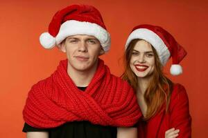 family in santa hats fun new year holiday red background photo