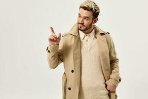 handsome man gesturing with hand beige coat modern style cropped view photo