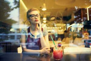 woman with glasses sitting alone in a cafe cocktail leisure lifestyle photo