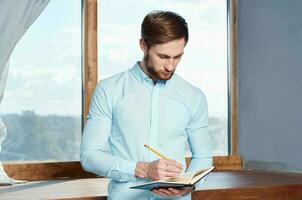 Handsome man writing on a book photo