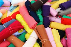 Detailed close up view on samples of cloth and fabrics in different colors found at a fabrics market photo