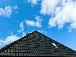 ventana de techo abierta en estilo velux con tejas negras. foto