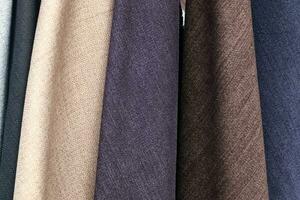 Detailed close up view on samples of cloth and fabrics in different colors found at a fabrics market photo