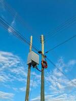 Wildly attached power cables to a power pole with a blue sky photo