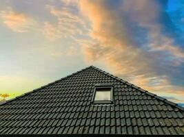 Open roof window in velux style with black roof tiles. photo