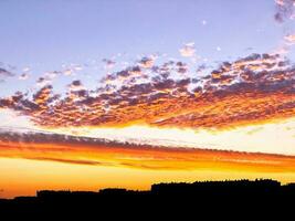 Red clouds over buildings in silhouette photo