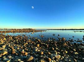 Rocky shore with calm sea at twilight photo