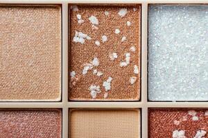 Eyeshadow colorful shades palette in beige tones close-up. Beauty abstract background photo