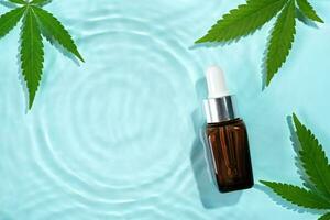 Beauty cosmetic lotion serum bottle and hemp leaves on water concentric circles background. Cosmetics CBD oil concept photo