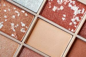 Eyeshadow colorful shades palette in beige tones close-up. Beauty abstract background photo