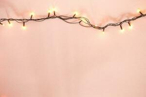 Yellow garland on a pink background. Holiday Christmas concept photo