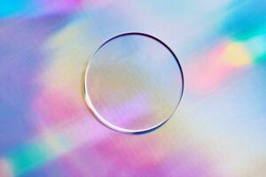 Empty round petri dish or glass slide on holographic background. Mockup for cosmetic or scientific product sample photo