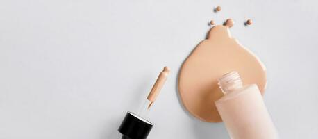 Banner with Mockup glass bottle of correction cosmetic product with pipette. Spilled Liquid foundation. Beauty branding concept photo