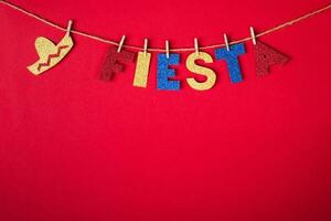 Fiesta word and sombrero on pins made of shiny paper on red background. Cinco de mayo concept photo