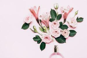 Floral arrangement with perfume bottle and pink flowers. Minimal beauty concept photo