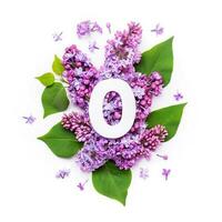 Paper number zero on background of lilac flowers. Minimal creative Layout with natural elements for your design photo