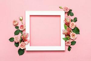 Arrangement of beautiful roses. White paper frame on pink background. Mothers day, Valentines Day, Birthday Greeting card photo