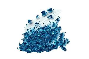 Blue glitter makeup product smear on white. Eye shadow, lip gloss and face for holiday makeup swatch photo