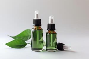 Cosmetic serum in a glass bottles with green leaves on light background. photo