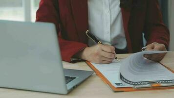 geschäftsleute und anwälte diskutieren vertragspapiere mit messingwaage auf dem schreibtisch im büro. gesetz, juristische dienstleistungen, beratung, justiz und gesetz konzeptbild mit filmkorneffekt video