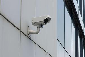 Security camera on modern building. CCTV on the wall in the city. photo