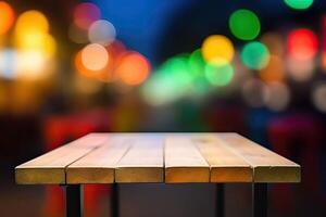 Wooden table in front of abstract blurred background of colorful restaurant lights. photo