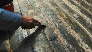 Applying glue with a spatula to the wooden floor gaps on the floor video