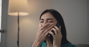 Asian Young woman using smartphone in hand and yawn photo