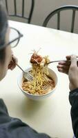 Close up of Asian man eating fried noodle and vegetable in restaurant photo