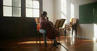 violoncelista ensayando en salón de clases video