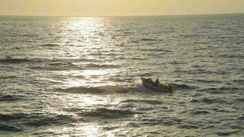 en små båt på hav på solnedgång går in i hamn. video