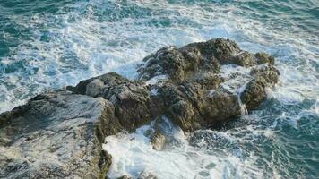 el olas choque en el rocas en verano y soleado días. video