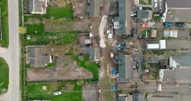 flying over a gravel road in a village with sheds and garden plots video