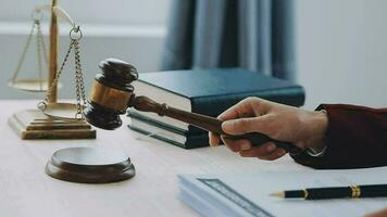 Justice and law concept.Male judge in a courtroom with the gavel, working with, computer and docking keyboard, eyeglasses, on table in morning light video