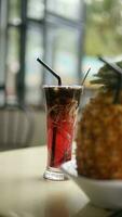 grated cucumber ice with red syrup in a long glass photo