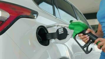 Woman pulls out a refueling gun from a car tank after finishing refueling video