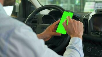 Driver using a smartphone inside the car. Chromakey smartphone with green screen. Auto navigation video