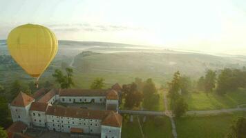 colorato caldo aria palloncini volare al di sopra di il medievale castello e lago nel il mattina nebbia. maneggevole volo. viaggiare, avventura, Festival. video