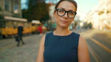 Woman walking down an old street and using smartphone at sunset. Communication, social networks, travel concept video