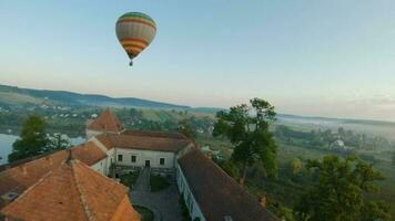 colorida quente ar balões mosca sobre a medieval castelo e lago dentro a manhã névoa. manobrável voo. viagem, aventura, festival. video