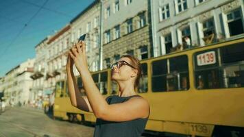 mulher caminhando baixa a velho rua e usando Smartphone às pôr do sol. comunicação, social redes, viagem conceito video