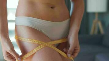 mujer medición su cintura con un medición cinta a hogar video