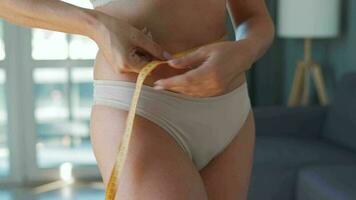 mujer medición su cintura con un medición cinta a hogar video