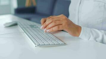 fêmea mãos digitando em uma computador teclado. conceito do controlo remoto trabalhos video