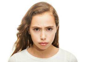 Grumpy young girl looking at the camera isolated on white background photo