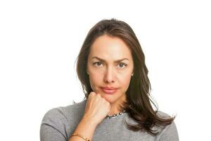 Upset unsatisfied woman standing with hand on chin and looking at camera isolated over white background photo