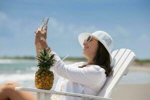 Beautiful woman taking selfies at a paradisiac tropical beach photo