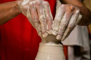 Man making ceramic articles on the potters wheel in a traditional factory in the city of Raquira located in the department of Cundinamarca in Colombia photo