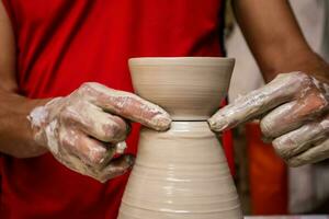 Man making ceramic articles on the potters wheel in a traditional factory in the city of Raquira located in the department of Cundinamarca in Colombia photo