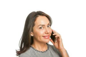 Young woman smiling and talking on her cellphone isolated on white background photo